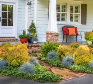 Beautifully landscaped entry drive and sidewalk lined with Fire Chief Arborvitae, Beyond Blue Festuca and Dragon Prince Cryptomeria