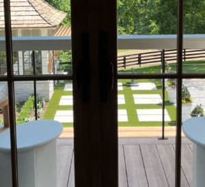 View through French doors onto balcony and back yard of Southern Living Idea House