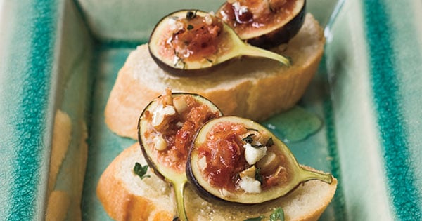 Fig Foccacia with sliced and set atop parchment on a blue table