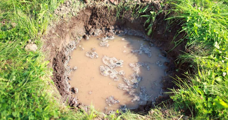 Hole dug in ground full of water